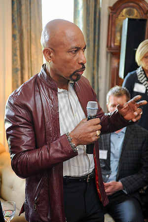 Montell Williams speaking with microphone in hand at fundraiser