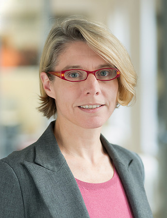 Portrait of woman wearing red glasses and grey blazer