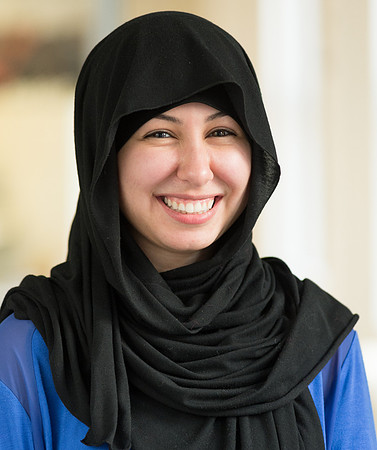 Portrait of smiling young women wearing a black head scarf.