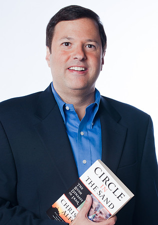 Portrait of Christian Alfonsi, author holding his book against white background