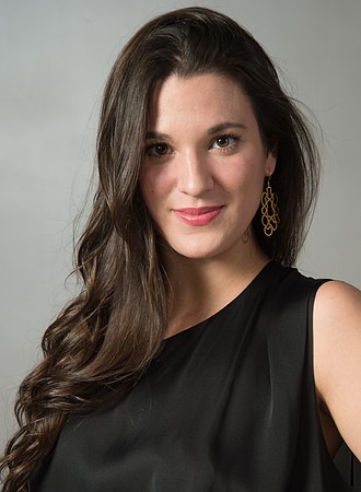 Portrait of young women with long hair in front of grey background