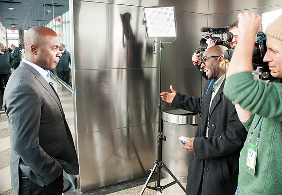 Football Hall of Famer Marshall Faulk speaking with reporter and cameras