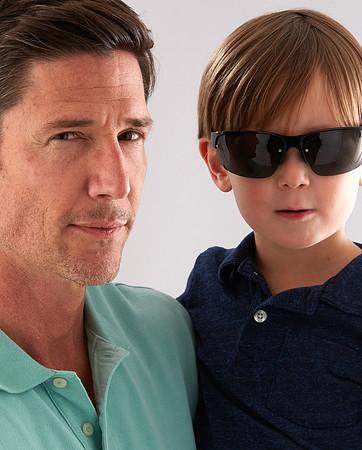 Portrait of a father holding his son who is wearing cool sunglasses