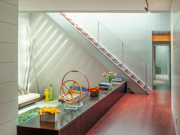 Modern sunken living room with sunlit shining through stairs