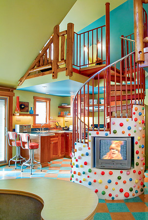 Colorful green and blue room with spiral staircase adorned with polkadots